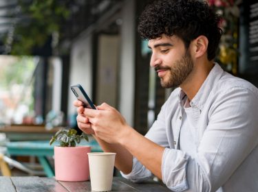 Mann checkt die Instagram-App auf seinem Smartphone.