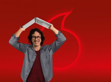 Mann hält Laptop als Dach über seinen Kopf