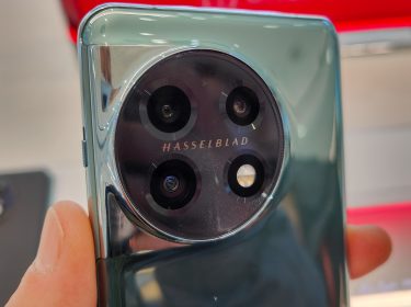 Hand hält das Smartphone OnePlus 11 in einem Handy-Geschäft