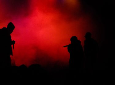Die Silhouette eines Rappers vor rotem Hintergrund