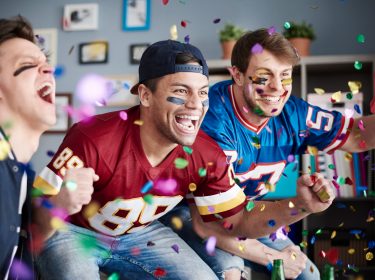 drei Freunde schauen gemeinsam den Super Bowl 57