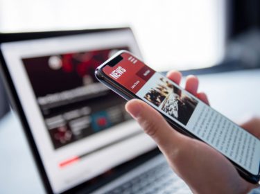 person liest neuigkeiten auf news app