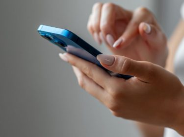 Frau hält iPhone in der Hand