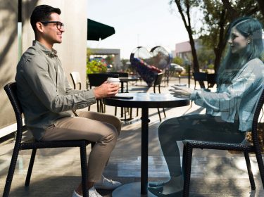 mann unterhält sich mithilfe von metas ar-brille mit hologramm von einer frau