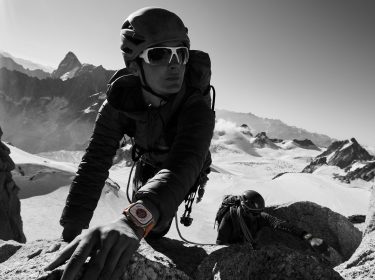 Sportler mit Smartwatch im Gebirge