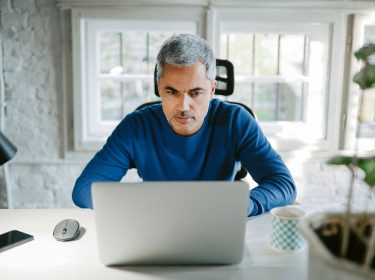 mann arbeitet konzentriert am laptop