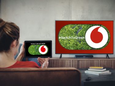 Eine Frau nutzt die grüne Mediathek von Vodafone Switch To Green – Schalt um auf Grün