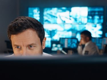 Polizist schaut auf Bildschirm