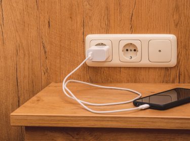 Ein Handy lädt an der Steckdose auf.