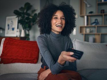 Eine Frau schaut sich eine Dokumentation in der GigaTV-Mediathek für Doku-Fans an