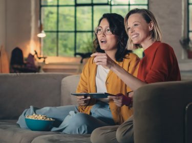 Zwei Frauen schauen gemeinsam GigaTV-Mediatheken für True-Crime-Fans