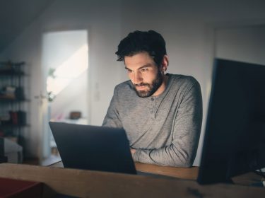 mann sitzt am laptop rückwegstörung
