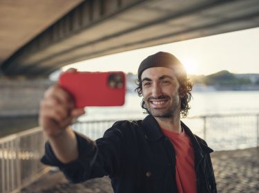 Mann hält Smartphone für ein Selfie