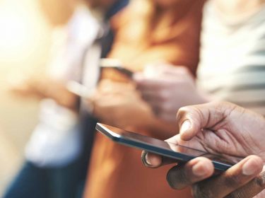 Mehrere Personen halten ihre Handys in der Hand