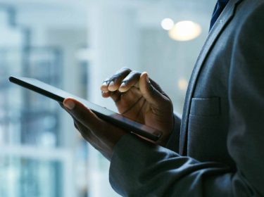 Hände eines Geschäftsmannes auf einem iPad