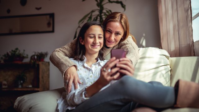 Auf dem Bild in dem Artikel zu den Vodafone Familientarifen ist eine Frau und eine junge Frau auf einem Sofa mit einem Handy zu sehen.
