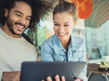 Frau schaut auf das Tablet von einem Mann