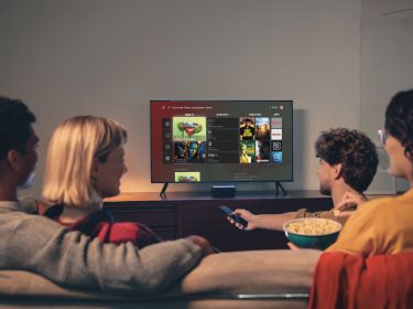 Freunde sitzen zusammen auf dem Sofa und schauen Vodafone GigaTV