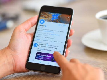 Ein Smartphone in einer Hand mit geöffneter Twitter-App