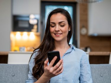 frau nutzt service-codes auf ihrem Smartphone