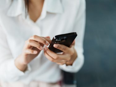 Frau öffnet Apple Wallet auf dem iPhone