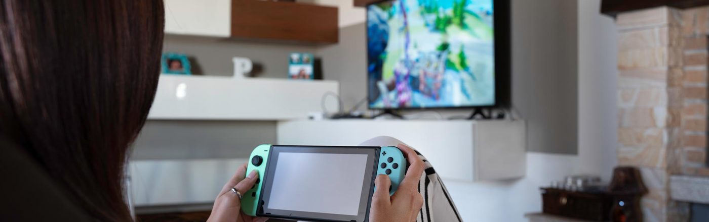Eine junge Erwachsene zockt Spiele auf der Nintendo Switch