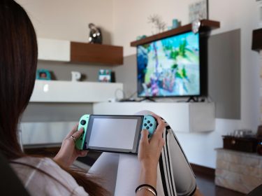 Eine junge Erwachsene zockt Spiele auf der Nintendo Switch