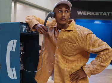 Teddy Teclebrhan steht an einer Telefonzelle