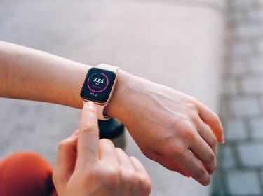 Jemand tippt auf seine Smartwatch am Arm beim Training