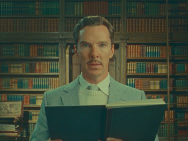 Benedict Cumberbatch schaut mit einem Buch in der Hand in die Kamera
