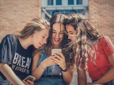 Mädchen schauen sich gemeinsam TechHacks auf dem Handy an