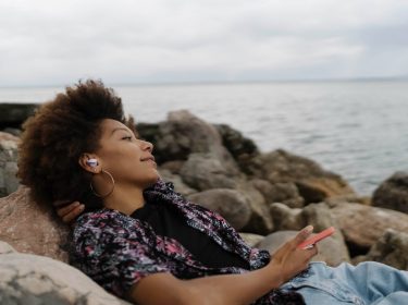 Junge Frau mit In-Ears am Wasser