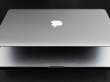 Ein Macbook auf einem schwarzen Holztisch