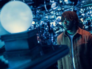 Ein junger Mann schaut auf eine Glaskugel in der Hallo der Prophezeigungen