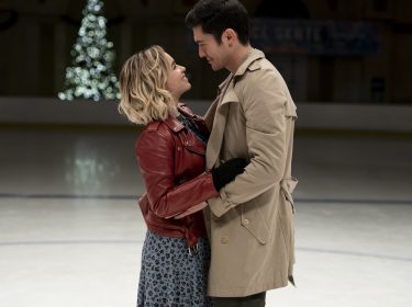 Tom und Katarina umarmen sich beim Schlittschuhlaufen auf der Eisfläche uns schauen sich tief in die Augen