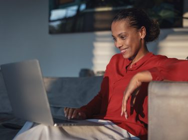 frau surft zuhause mit laptop im internet