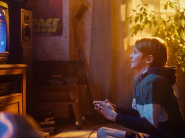 junge spielt in den 80er jahren videospiele daheim