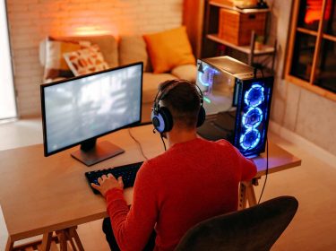 Ein Mann sitzt vor seinem Computer und spielt Videospiele