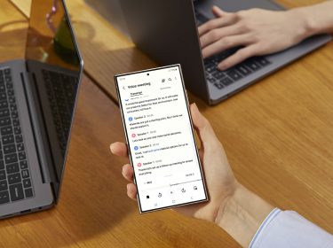 Das Galaxy S24 Ultra wird über einem Tisch in der Hand gehalten