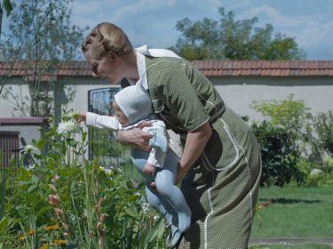 Eine Frau mit Baby im Garten