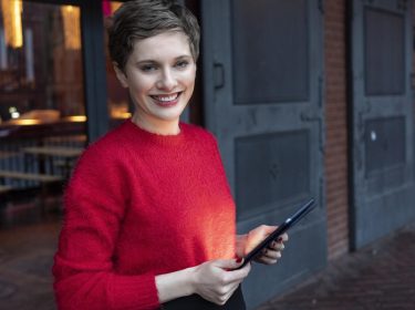 Eine junge Frau mit einem Tablet in den Händen.