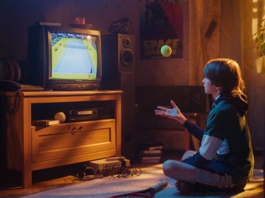 Ein Junge schaut gespannt einen Sport-Moment der TV-Geschichte