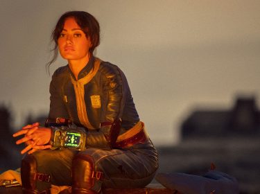 Hauptfigur Lucy aus der Fallout-Serie sitzt in der untergehenden Sonne