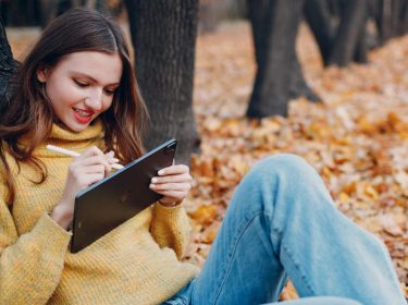 Frau schreibt mit Apple Pencil auf dem iPad Pro.