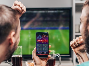 zwei freunde gucken fußball und nutzen eine der besten fußball apps