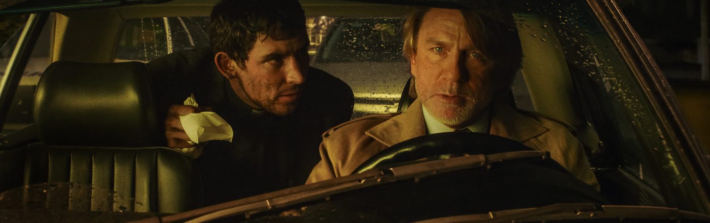 Eine Szene aus Wake Up Dead Man: A Knives Out Mystery. Daniel Craig und Josh O’Connor im Auto