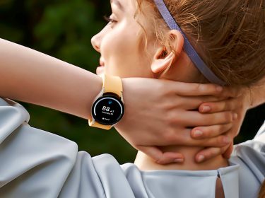 Junge Frau in Sportbekleidung mit Smartwatch von Samsung.