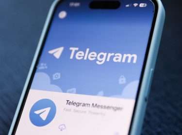 Ein Smartphone, auf dessen Display der Messenger Telegram zu sehen ist