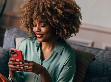 Frau schaut auf ihr iPhone.