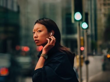 Junge Frau mit Smartwatch und In-Ears